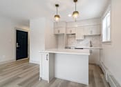 Thumbnail 119 of 219 - A kitchen with white cabinets and a white island.