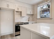 Thumbnail 118 of 219 - A kitchen with white cabinets and a marble backsplash.