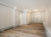 Thumbnail 134 of 219 - A room with white walls and wooden flooring with a white door on the left and a white wardrobe on the right.