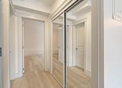 Thumbnail 127 of 219 - A hallway with a wooden floor and white walls.