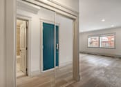 Thumbnail 124 of 219 - A room with a blue door and wooden flooring.