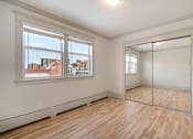 Thumbnail 106 of 219 - A room with a wooden floor and a large mirror on the wall.