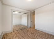 Thumbnail 105 of 219 - A room with a wooden floor and white walls.