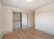 Thumbnail 104 of 219 - A room with a sliding door and wooden flooring.
