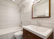 Thumbnail 102 of 219 - A white bathroom with a white toilet, white sink, and white bathtub.
