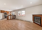 Thumbnail 117 of 219 - A large, empty room with a fireplace and wooden floors.