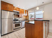 Thumbnail 115 of 219 - A modern kitchen with wooden cabinets and stainless steel appliances.