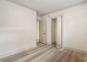 Thumbnail 87 of 219 - A room with a white door and a wooden floor.