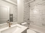 Thumbnail 85 of 219 - A white bathroom with a marble tile wall.