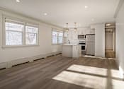 Thumbnail 82 of 219 - A spacious kitchen with wooden floors and white cabinetry.