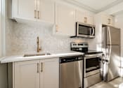 Thumbnail 78 of 219 - A kitchen with a stove, oven, refrigerator, and sink.