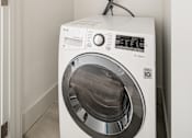 Thumbnail 97 of 219 - A white washing machine in a small laundry room.