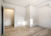 Thumbnail 91 of 219 - A room with a wooden floor and white walls.