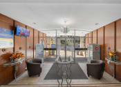 Thumbnail 25 of 33 - the lobby of a building with chairs and a glass door