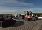 Thumbnail 21 of 27 - A wooden deck with red cushioned seating.