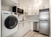 Thumbnail 149 of 219 - A modern kitchen with a washing machine and a refrigerator.