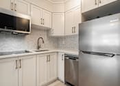 Thumbnail 148 of 219 - A kitchen with a stainless steel refrigerator and a microwave above the sink.