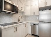Thumbnail 147 of 219 - A kitchen with a stainless steel refrigerator and a microwave above the stove.