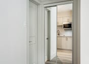 Thumbnail 146 of 219 - A white door is open to a kitchen.