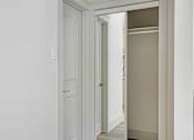 Thumbnail 145 of 219 - A white door is open to a hallway.