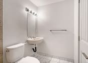 Thumbnail 144 of 219 - A white bathroom with a toilet, sink, and mirror.