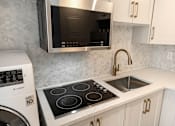 Thumbnail 142 of 219 - A modern kitchen with a stainless steel microwave above the stove.