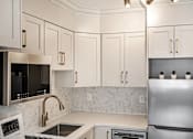 Thumbnail 140 of 219 - A kitchen with a stainless steel refrigerator, microwave, and oven.