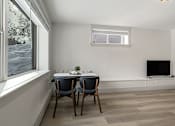 Thumbnail 157 of 219 - A room with a table and chairs and a television.