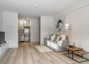 Thumbnail 152 of 219 - A modern living room with a grey sofa and a wooden coffee table.