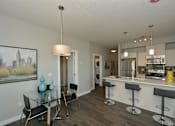 Thumbnail 14 of 42 - A modern kitchen with a bar area and a dining table.