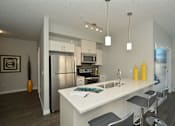 Thumbnail 15 of 42 - A modern kitchen with a white island and stainless steel appliances.