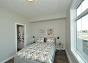 Thumbnail 9 of 42 - A bedroom with a bed, two lamps, and a painting on the wall.