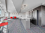 Thumbnail 25 of 27 - A modern kitchen with a bar area and seating.