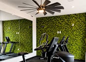 Thumbnail 6 of 28 - State-of-the-art fitness center featuring cardio equipment, mirrored walls, designer finishes, and a living green wall at 200 Main Kannapolis.