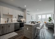 Thumbnail 14 of 66 - Designer kitchen with quartz countertops, bar seating, and two-tone cabinetry—part of the modern luxury amenities at The Rail Bound Brook.