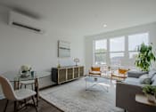 Thumbnail 20 of 66 - Bright living room at The Rail at Bound Brook featuring oversized windows, modern decor, and natural light—luxury apartment living in NJ.