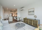 Thumbnail 22 of 66 - Contemporary kitchen at The Rail featuring white cabinetry, subway tile backsplash, stainless steel appliances, and natural light from large windows.
