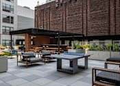 Thumbnail 8 of 72 - Outdoor lounge and ping pong table at The Rail at Bound Brook, a luxury apartment community in Downtown Bound Brook, NJ.