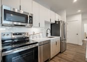 Thumbnail 14 of 33 - Contemporary kitchen with stainless steel appliances and custom cabinetry in a pet-friendly apartment near downtown Bound Brook, NJ.