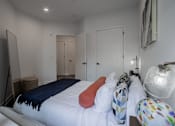 Thumbnail 19 of 33 - Interior of a luxury bedroom with modern lighting and closet access in a pet-friendly apartment near downtown Bound Brook.