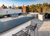 Thumbnail 14 of 18 - a kitchen and dining area on a roof with a city skyline in the background