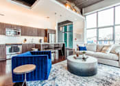 Thumbnail 18 of 18 - a living room with a couch coffee table and a kitchen with a breakfast bar