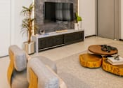 Thumbnail 16 of 18 - a living room with a tv on the wall and a coffee table in front of it