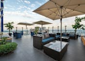 Thumbnail 9 of 17 - A patio with a table and chairs under a large umbrella.