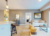 Thumbnail 5 of 102 - A living room with a white couch and a wooden floor.