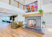 Thumbnail 21 of 102 - A living room with a fireplace and a painting above it.