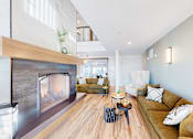 Thumbnail 22 of 102 - A modern living room with a fireplace and a couch.