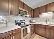 Thumbnail 2 of 98 - A kitchen with brown cabinets and a white counter.