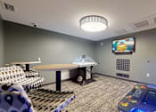 Thumbnail 30 of 102 - A room with a table, chairs, and a television mounted on the wall.