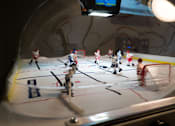 Thumbnail 31 of 102 - A group of small plastic people are playing a game of hockey on a table.
